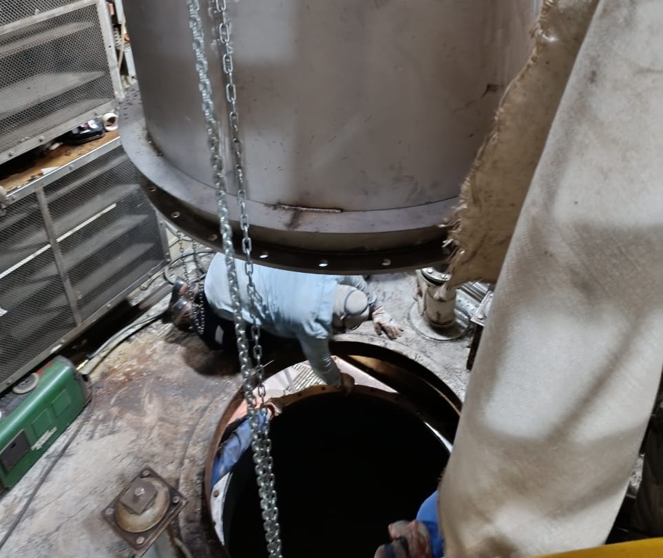 Industrial marine pipe fitter installing heavy-duty funnel pipe fitting infrastructure on a vessel.