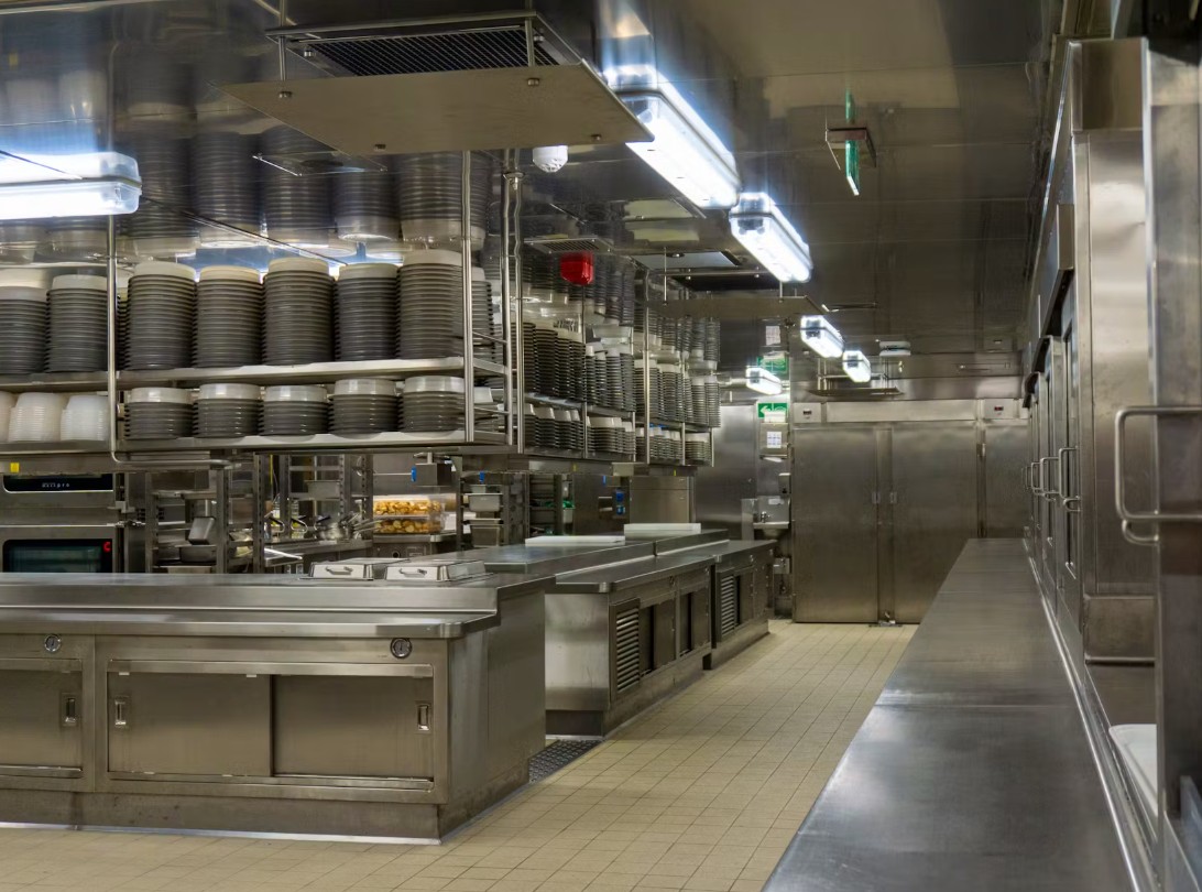 Custom welded stainless steel commercial kitchen counters and galley infrastructure on a marine vessel.